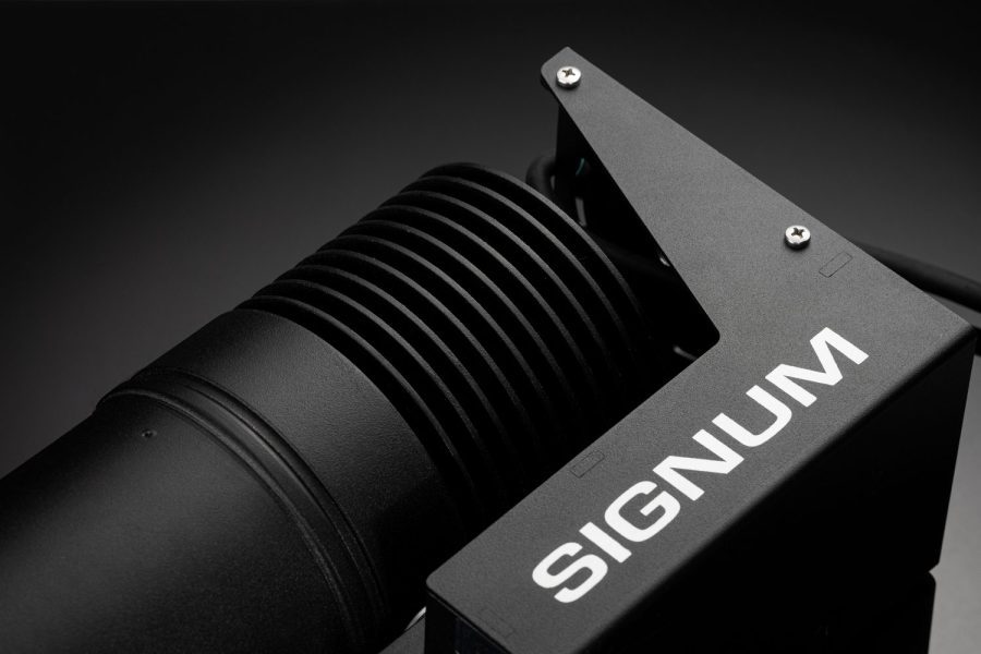 Primer plano de un dispositivo de iluminación profesional negro con la marca 'SIGNUM' en su estructura metálica